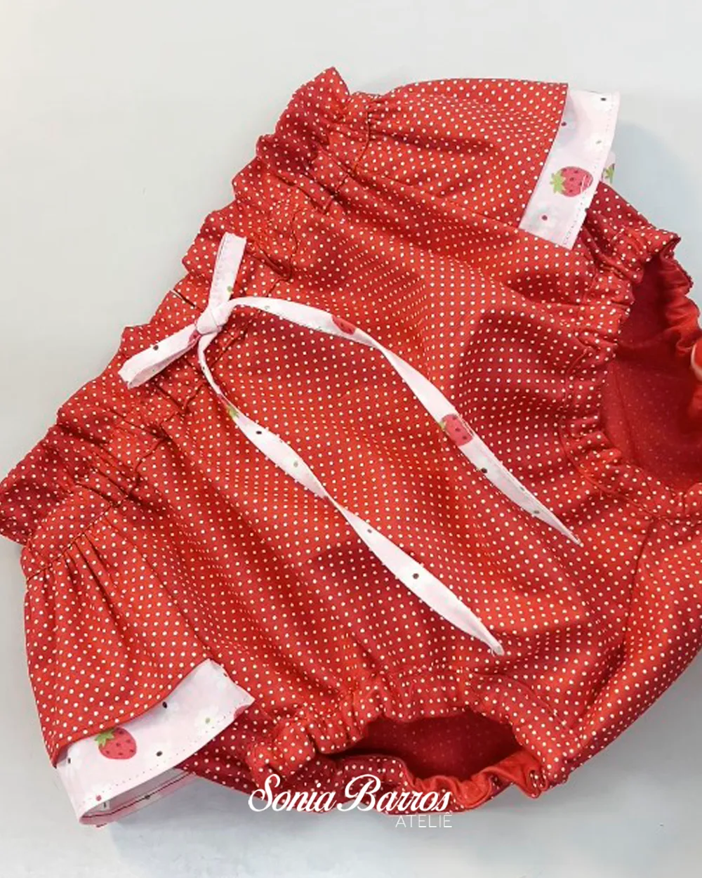 Tapa-fraldas vermelho com babados e laço